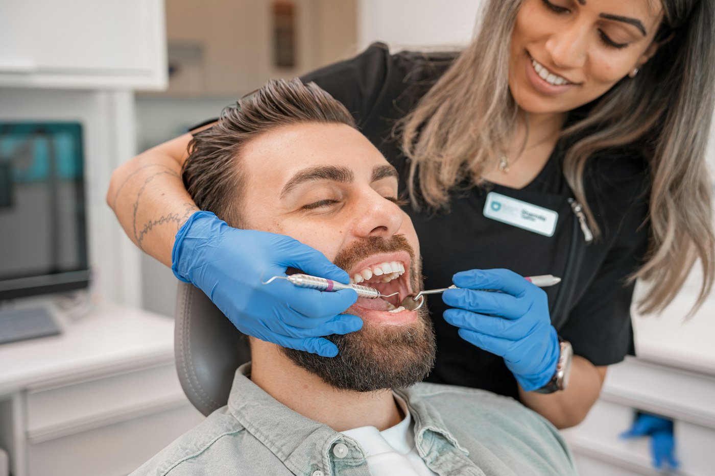 A dentist examining a patient's teeth in a dental office